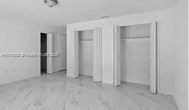an empty room with closet and a window