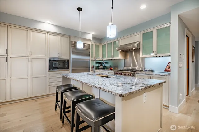 a kitchen with kitchen island a wooden floor and a refrigerator