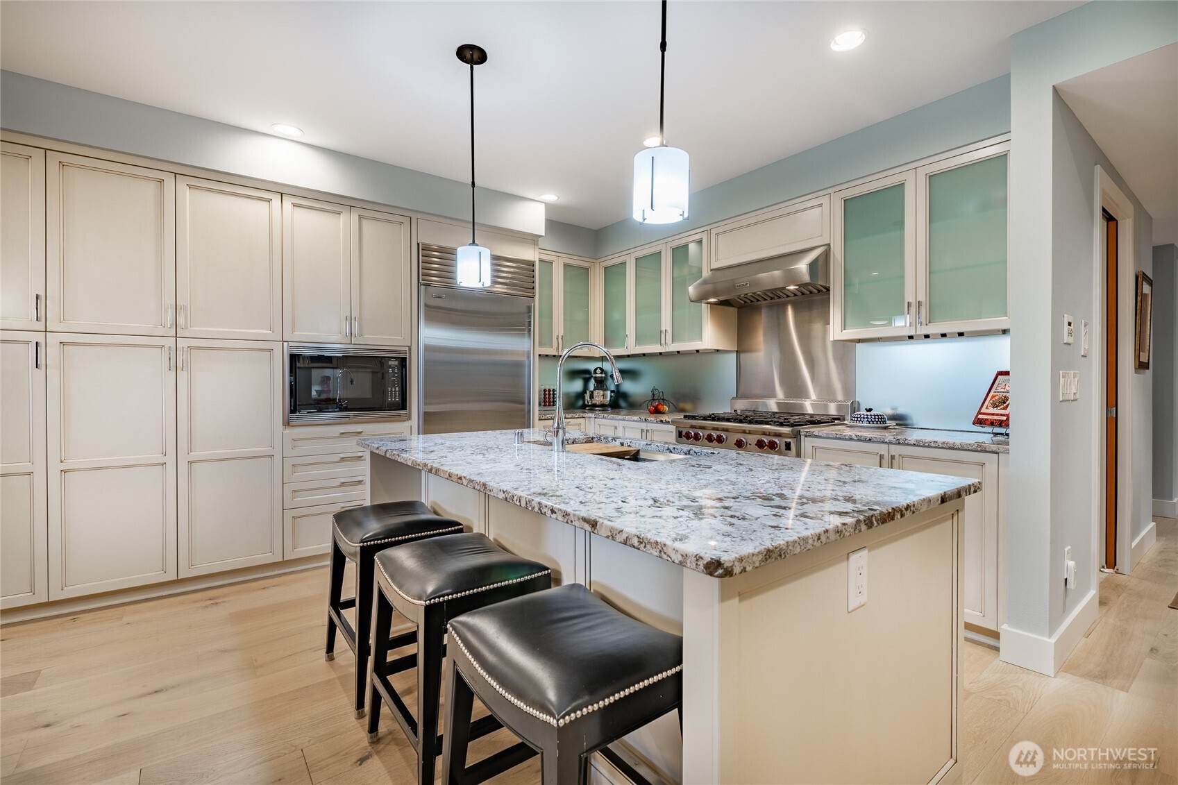 9525 Semiahmoo Parkway, Unit A204 Blaine, WA 98230 - Photo 15 of 37 a kitchen with kitchen island a wooden floor and a refrigerator