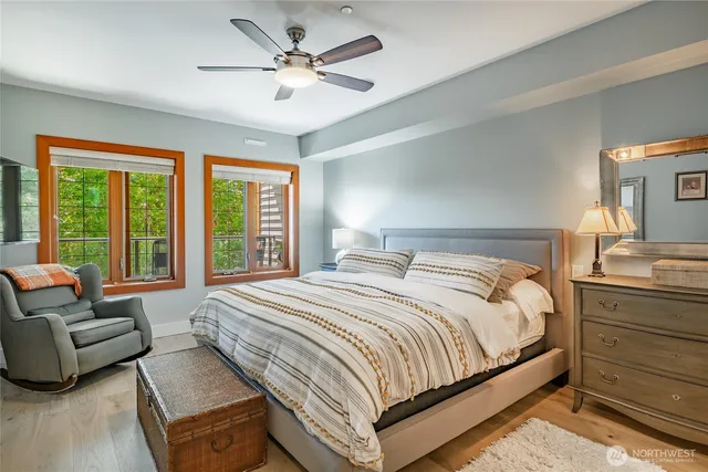 a bedroom with a bed couch and a large window