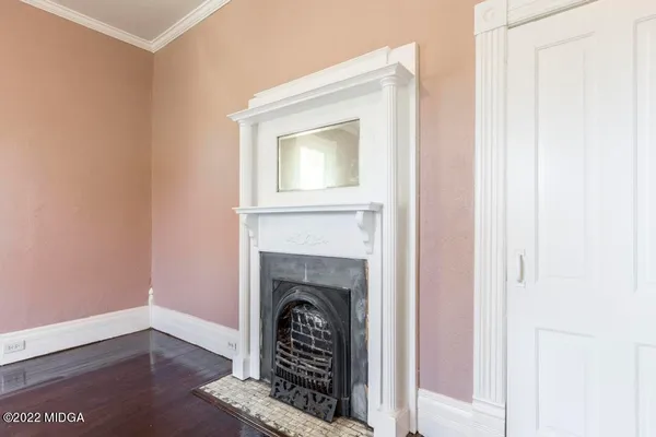 a view of empty room with fireplace and wooden floor