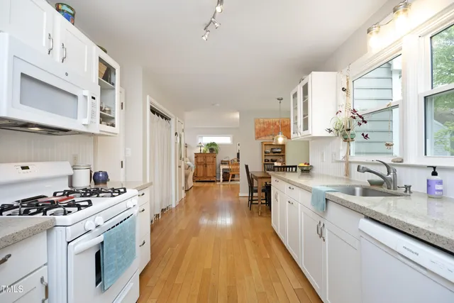 a kitchen with stainless steel appliances a sink a stove top oven a counter space and cabinets
