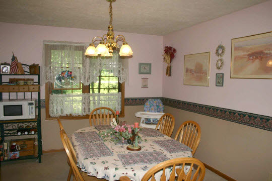 229 Rochester Road Northeast Poplar Grove, IL 61065 - Photo 4 of 6 a dining room with furniture a chandelier and window
