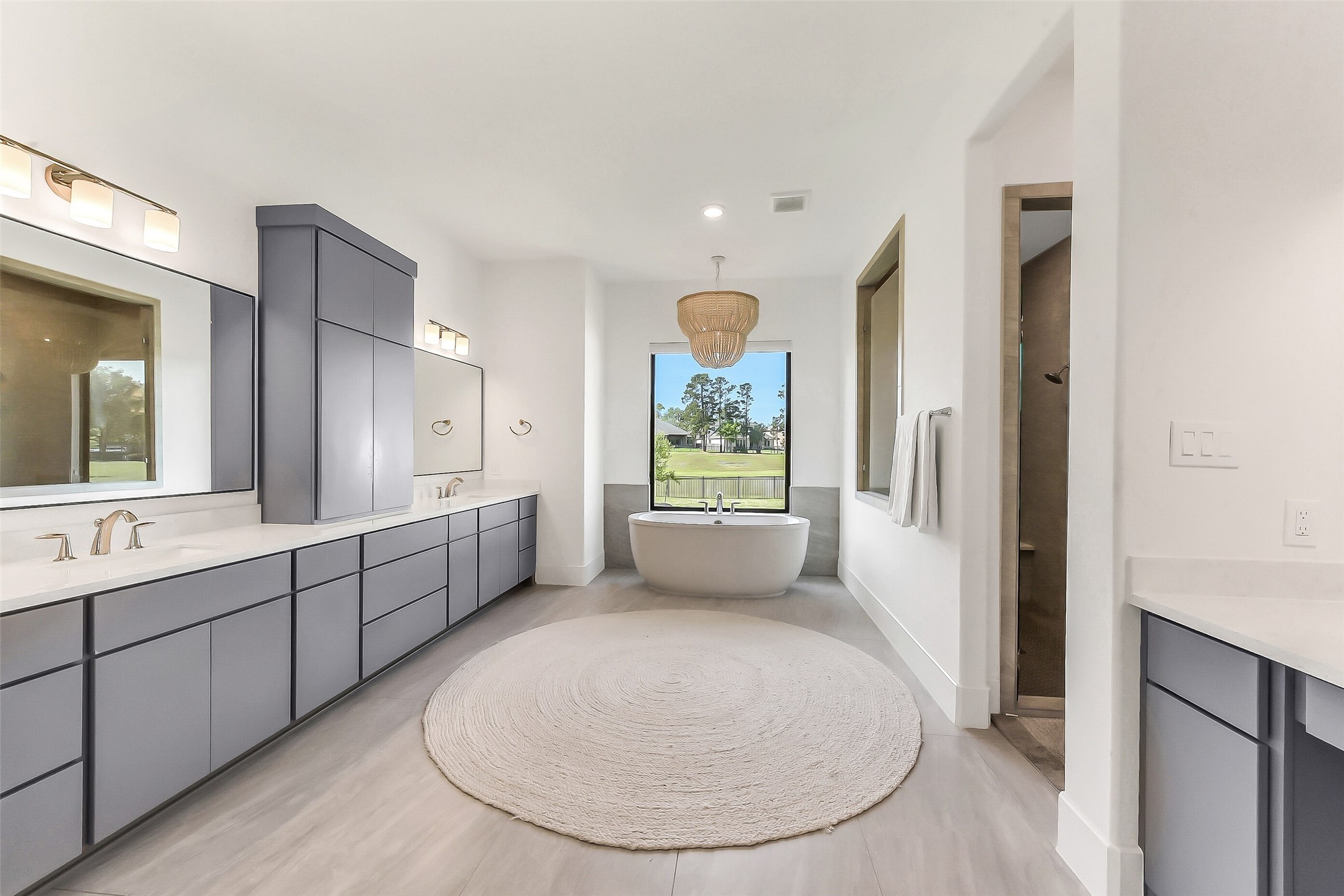 4903 Lagos Lagoon Way Spring, TX 77389 - Photo 25 of 49 Extended spa-inspired primary bath with dual sinks, separate vanity, and a freestanding soaking tub perfectly positioned beneath a picture window and tranquil lake views.
