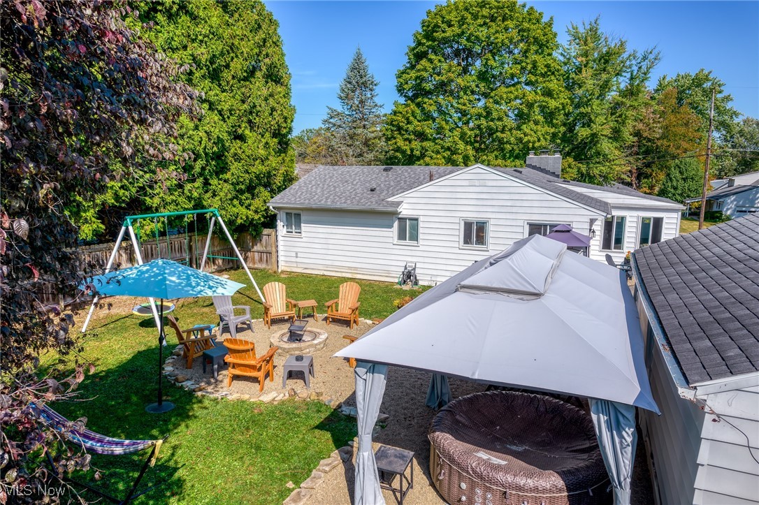 2514 Carson Road Akron, OH 44333 - Photo 28 of 48 Rear view of property featuring a fire pit, a patio, a playground, a chimney, and a shingled roof