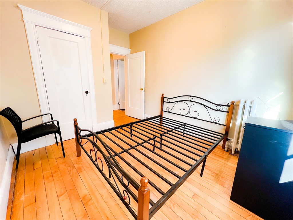 68 Forest Park Avenue Springfield, MA 01108 - Photo 10 of 19 a bedroom with a bed and wooden floor