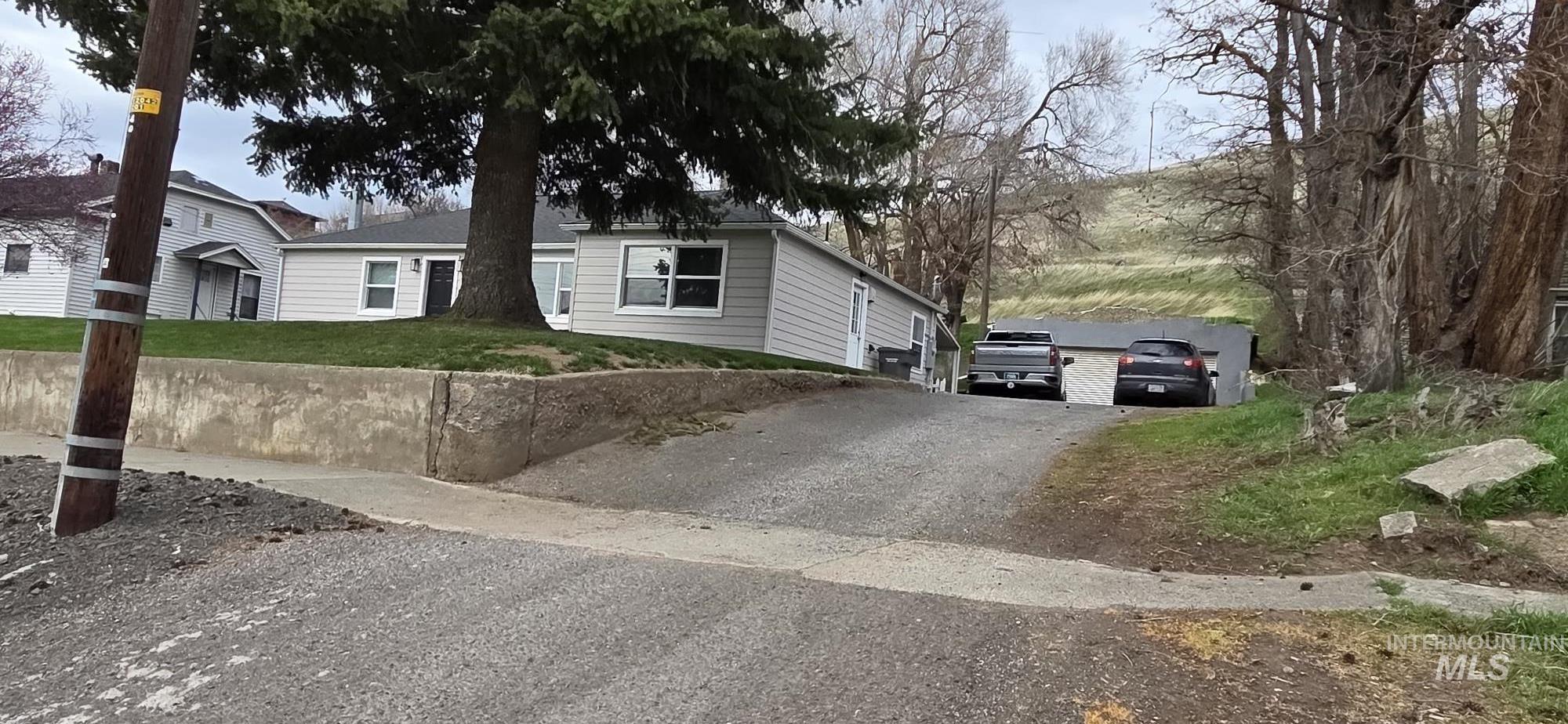 Ranch-style home with asphalt driveway and a front lawn