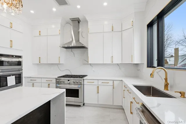 a large white kitchen with lots of counter space wooden floor and appliances