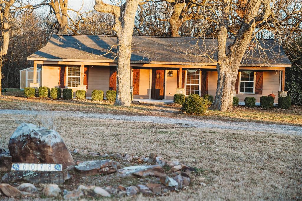 Ranch-style house featuring a porch and roof with shingles