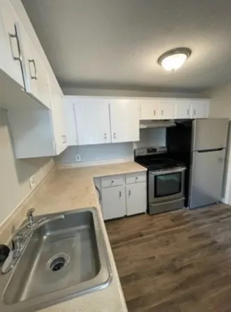 a kitchen with a sink a stove and cabinets