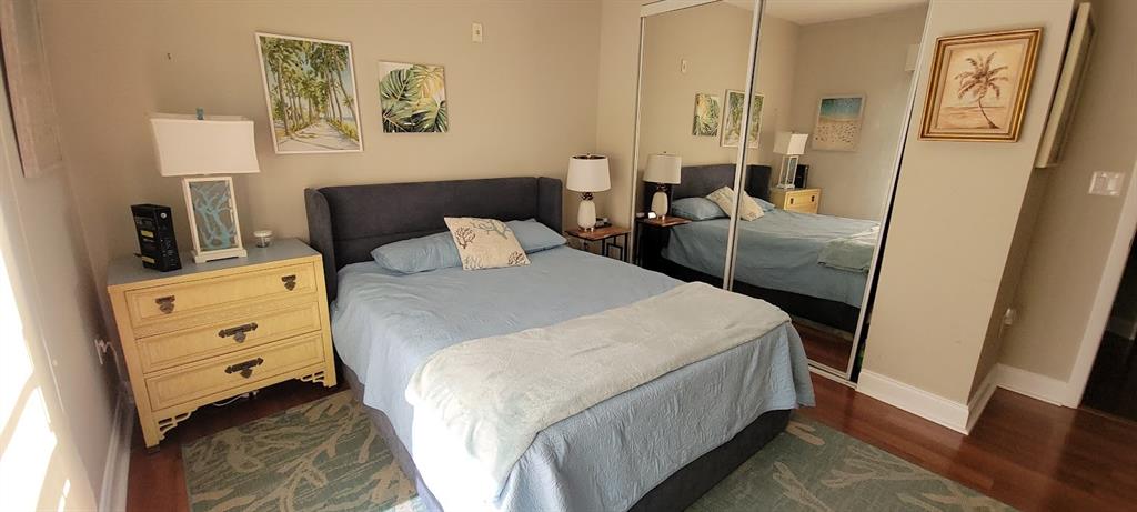 2509 North Ocean Boulevard, Unit 576 Fort Lauderdale, FL 33305 - Photo 18 of 22 a bedroom with a bed and wooden floor