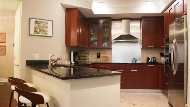 a kitchen with granite countertop a sink cabinets and stainless steel appliances