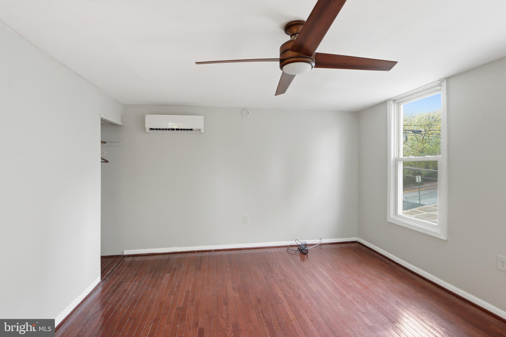 3544 Ash Street Baltimore, MD 21211 - Photo 13 of 17 an empty room with wooden floor fan and windows