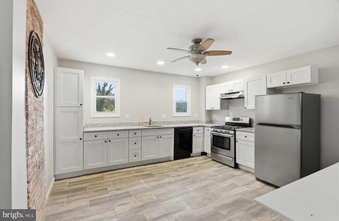 3544 Ash Street Baltimore, MD 21211 - Photo 3 of 17 a kitchen with cabinets stainless steel appliances and a window