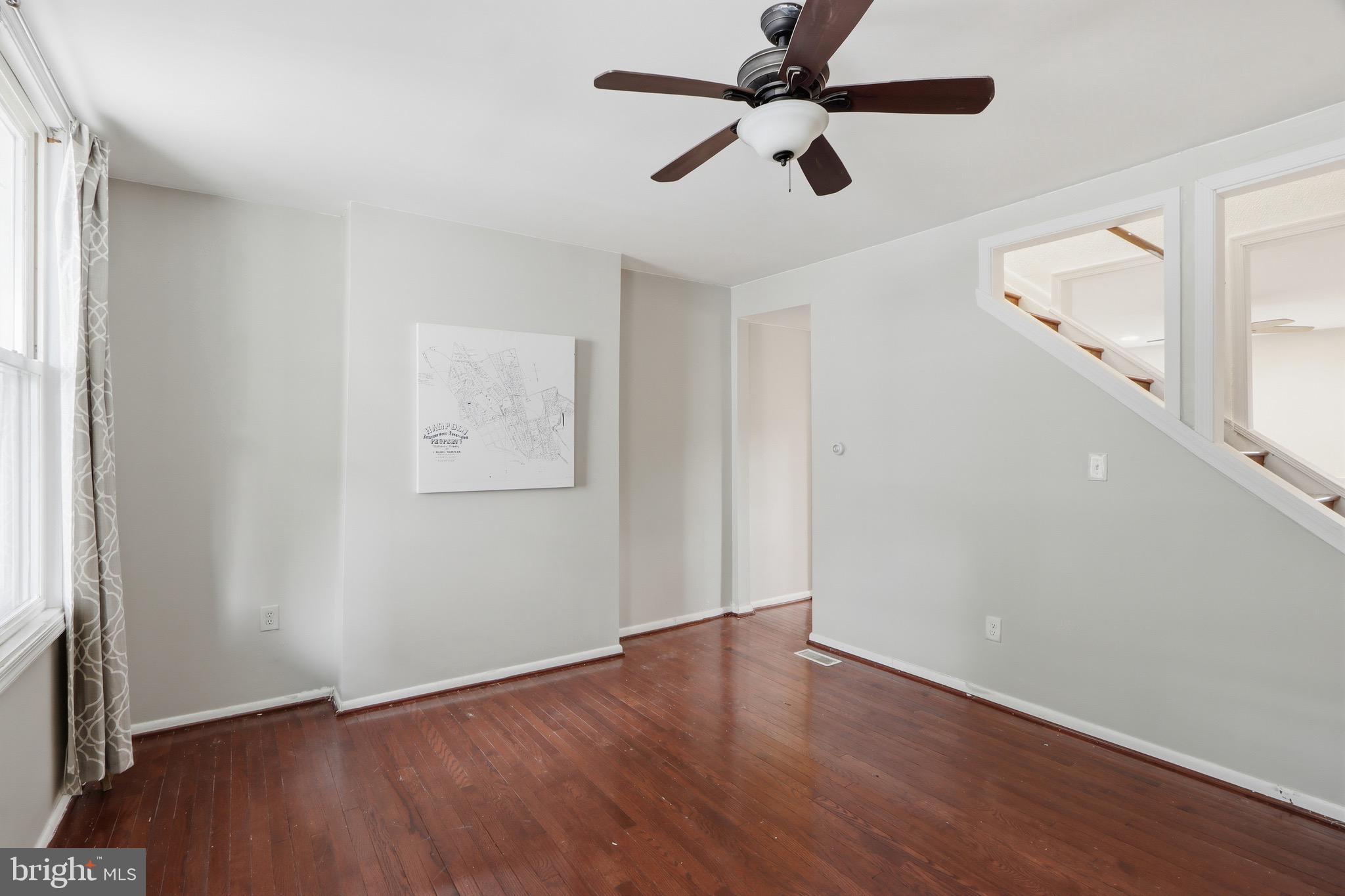 3544 Ash Street Baltimore, MD 21211 - Photo 7 of 17 an empty room with wooden floor ceiling fan and windows