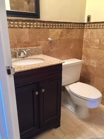 a bathroom with a granite countertop toilet a sink and bathtub
