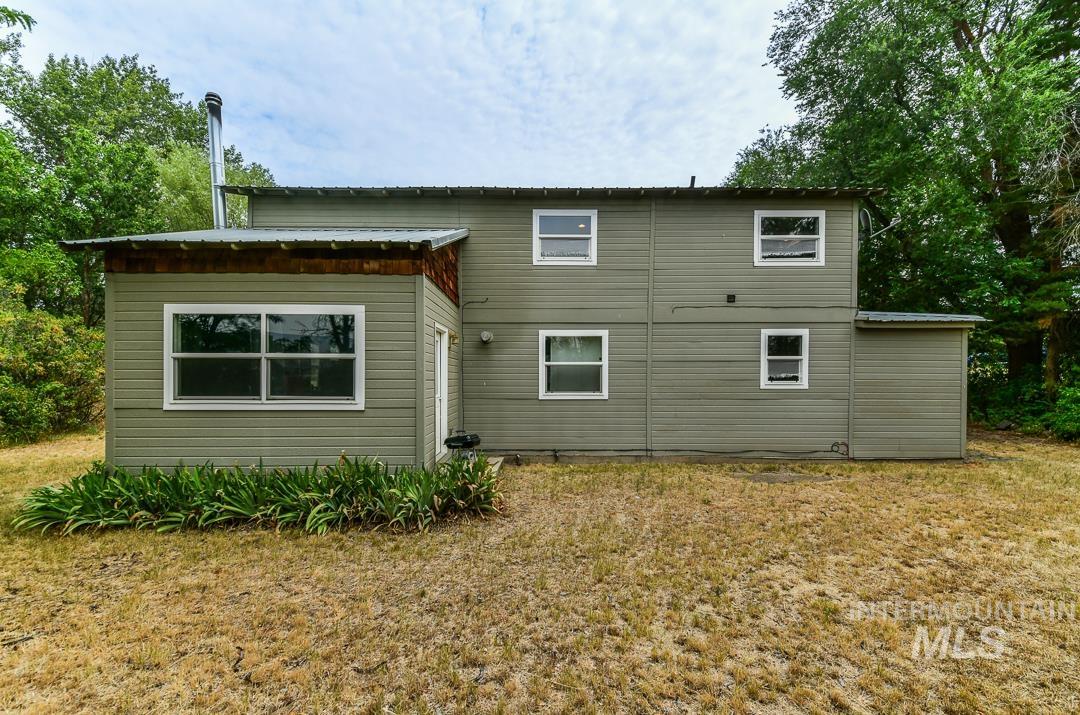 595 Cemetery Road Cambridge, ID 83610 - Photo 34 of 47 Two-story exterior with horizontal siding and multiple windows, featuring a metal roof and an attached shed
