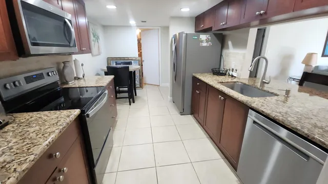 a kitchen with stainless steel appliances granite countertop a sink stove and refrigerator