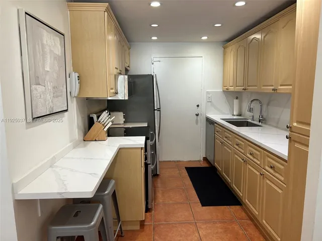 a kitchen with a sink a refrigerator and cabinets