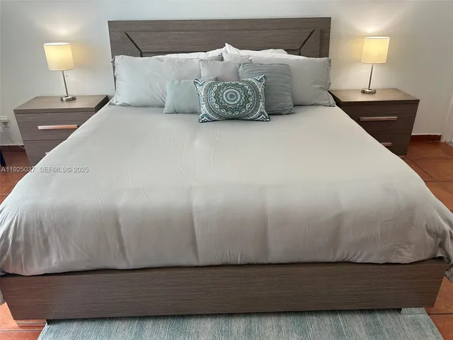 a large bed sitting in a bedroom with a lamp