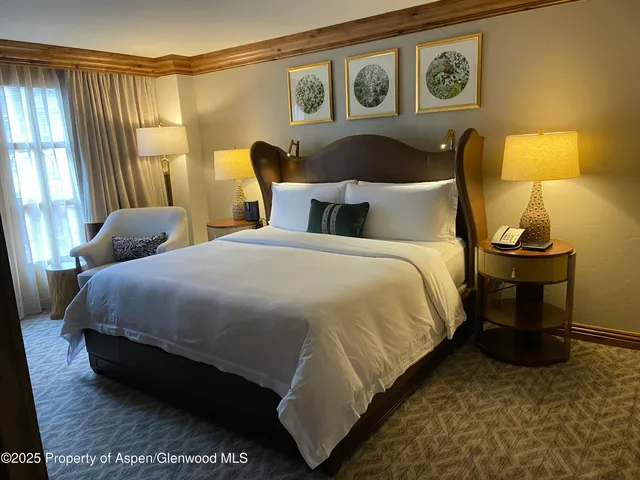 a bed sitting in a bedroom next to a lamp