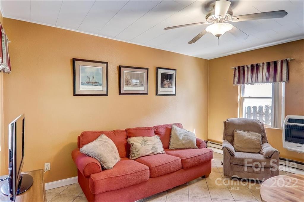 1555 Soco Road, Unit 3 Maggie Valley, NC 28751 - Photo 13 of 40 a blue couch sitting in a living room with furniture and a window