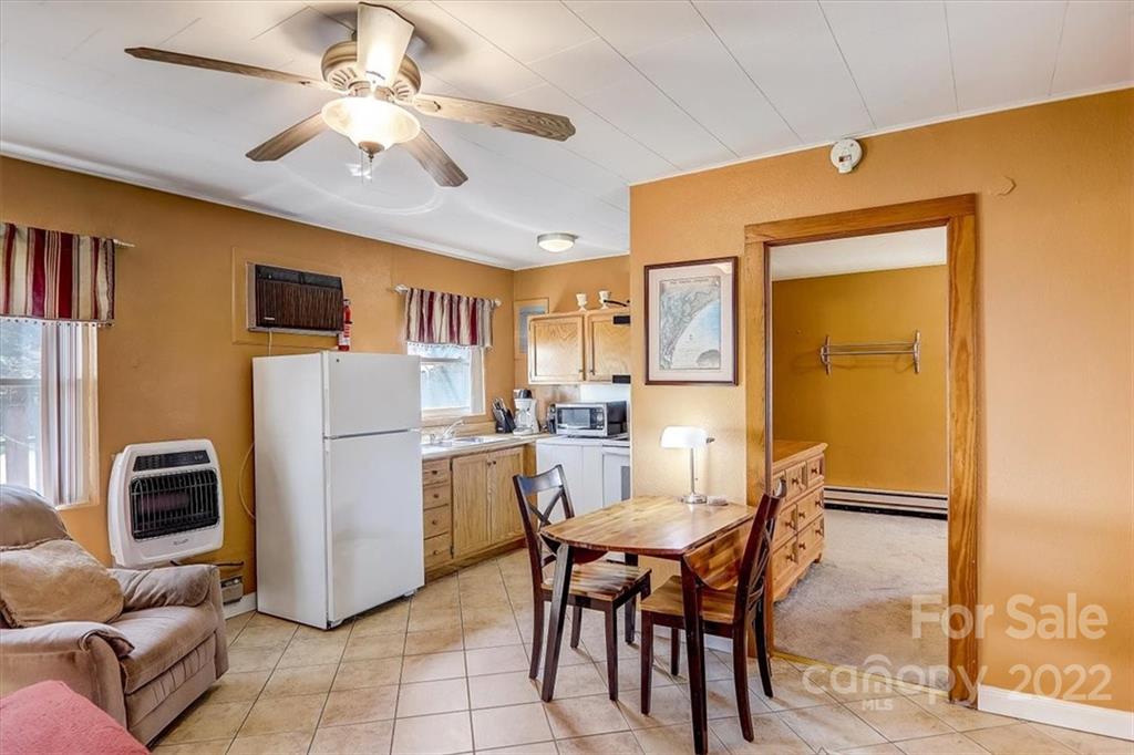 1555 Soco Road, Unit 3 Maggie Valley, NC 28751 - Photo 19 of 40 a dining room with furniture a refrigerator and a livingroom