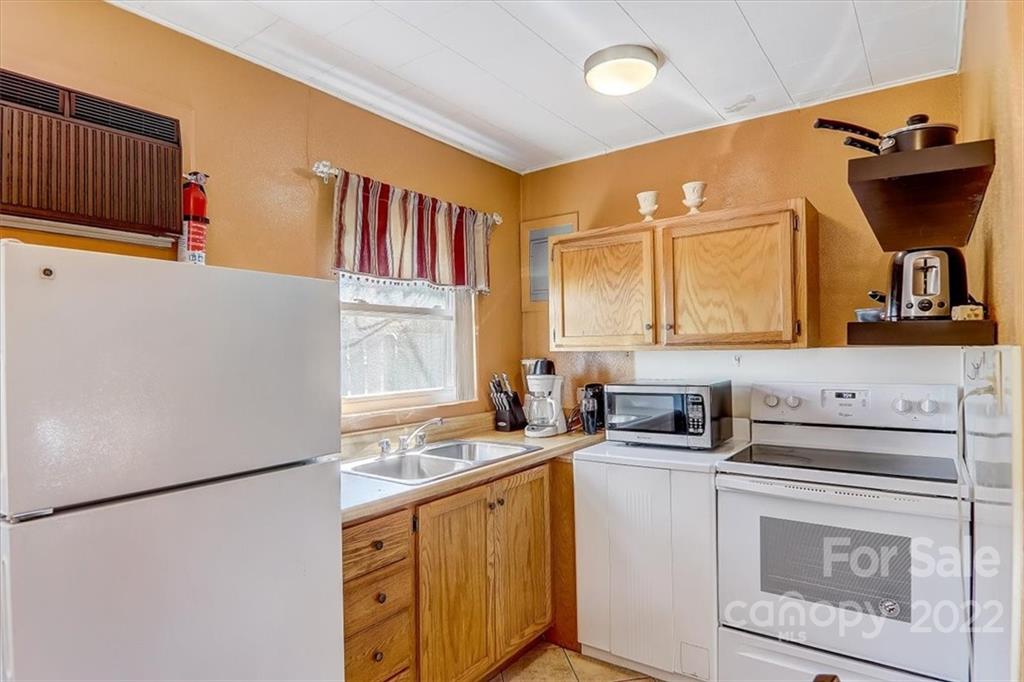 1555 Soco Road, Unit 3 Maggie Valley, NC 28751 - Photo 20 of 40 a kitchen with stainless steel appliances a refrigerator sink and white cabinets