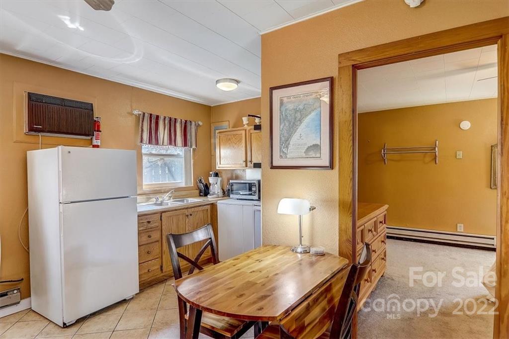 1555 Soco Road, Unit 3 Maggie Valley, NC 28751 - Photo 23 of 40 a kitchen with a refrigerator a stove top oven a washer and dryer