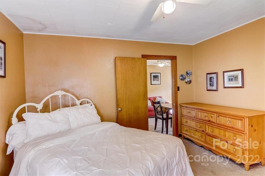 1555 Soco Road, Unit 3 Maggie Valley, NC 28751 - Photo 27 of 40 a bedroom with a bed and a dresser