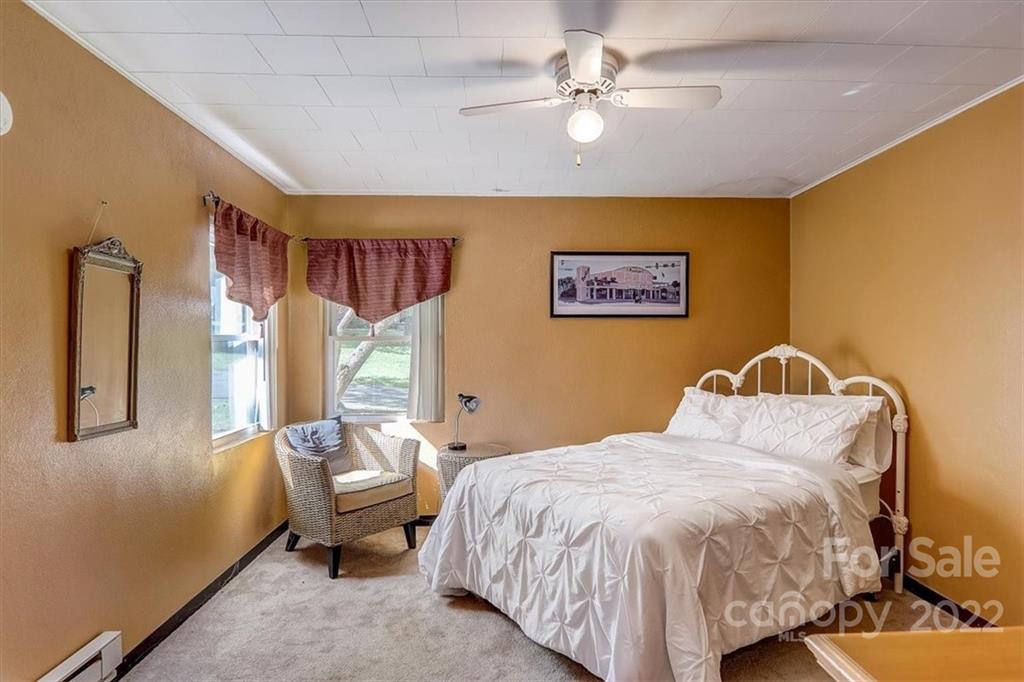 1555 Soco Road, Unit 3 Maggie Valley, NC 28751 - Photo 29 of 40 a bedroom with a bed and a chandelier