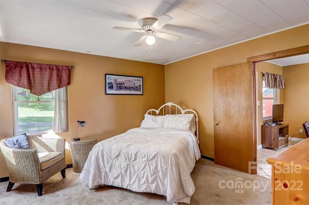 1555 Soco Road, Unit 3 Maggie Valley, NC 28751 - Photo 30 of 40 a bedroom with a bed a couch and a window