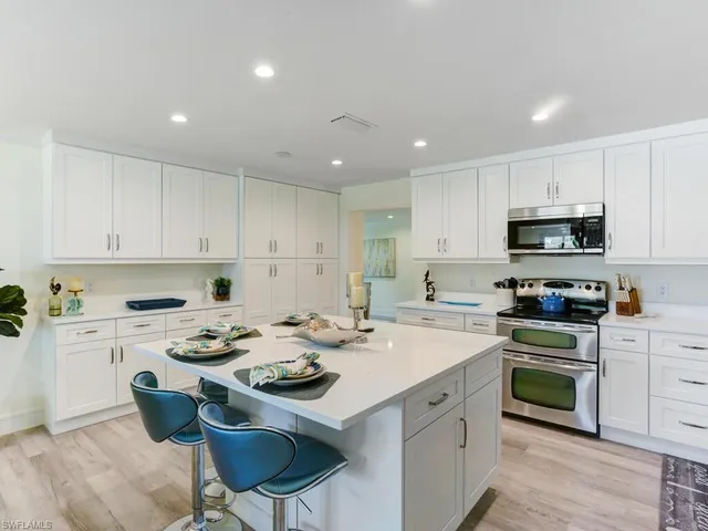 a kitchen with a stove a sink a dining table and chairs