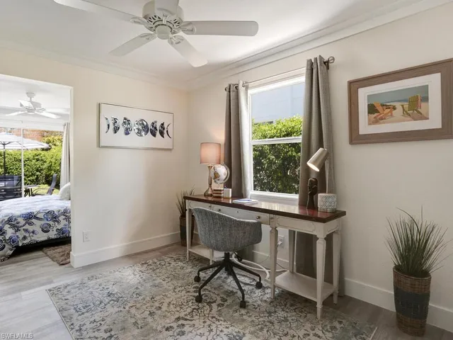 a view of a workspace with furniture and a window