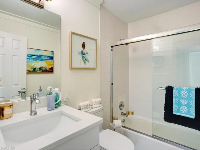 a bathroom with a granite countertop sink mirror vanity and toilet