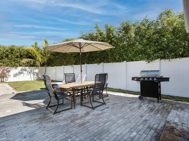 a view of a roof deck with table and chairs under an umbrella