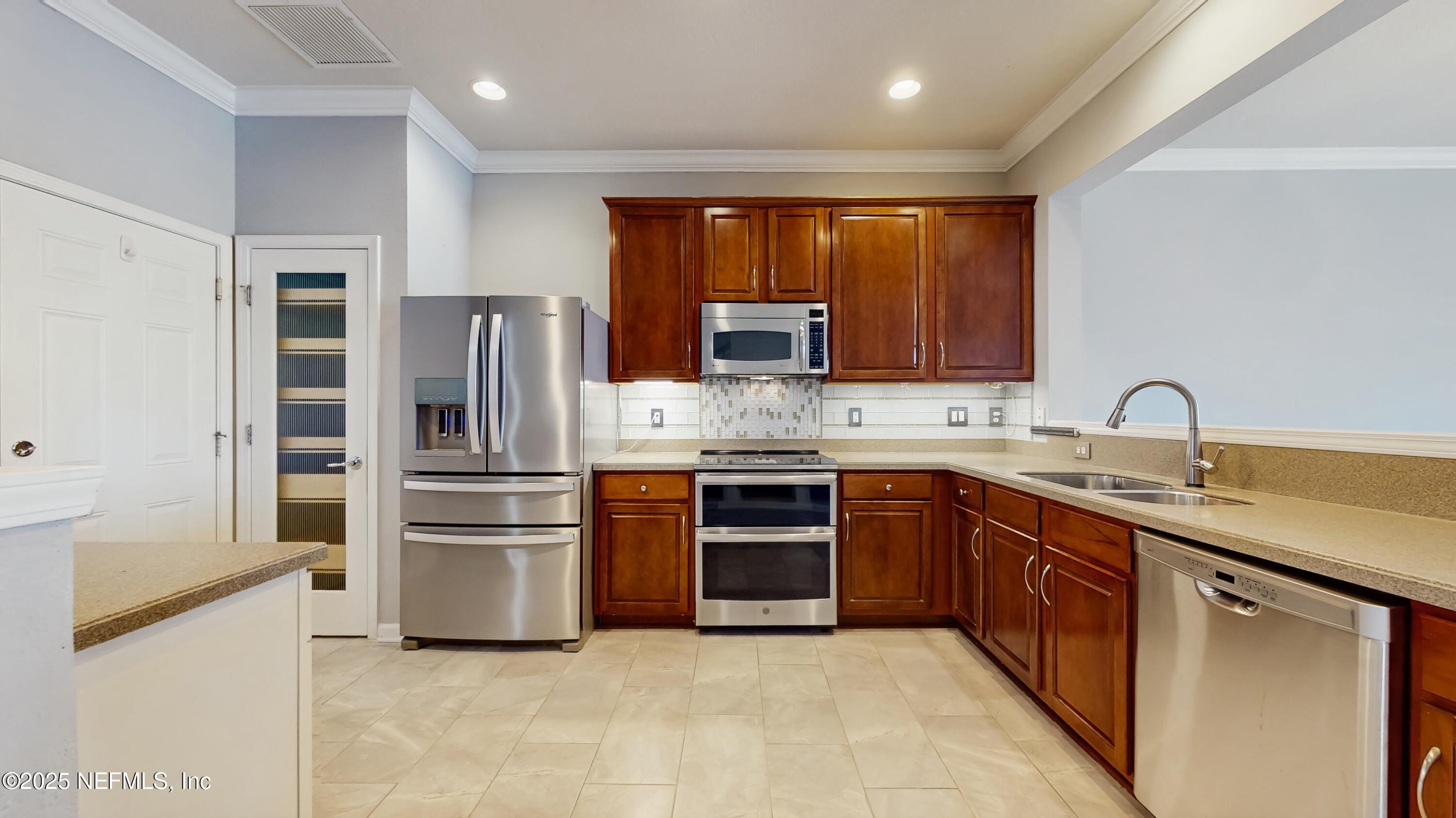 7030 Roundleaf Drive Jacksonville, FL 32258 - Photo 3 of 39 a kitchen with stainless steel appliances granite countertop a refrigerator and a stove top oven