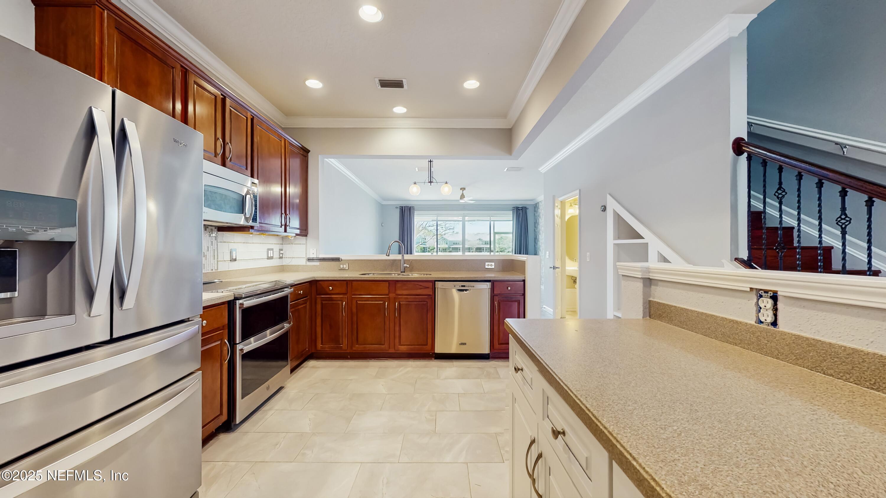 7030 Roundleaf Drive Jacksonville, FL 32258 - Photo 4 of 39 a kitchen with stainless steel appliances kitchen island granite countertop a sink and cabinets