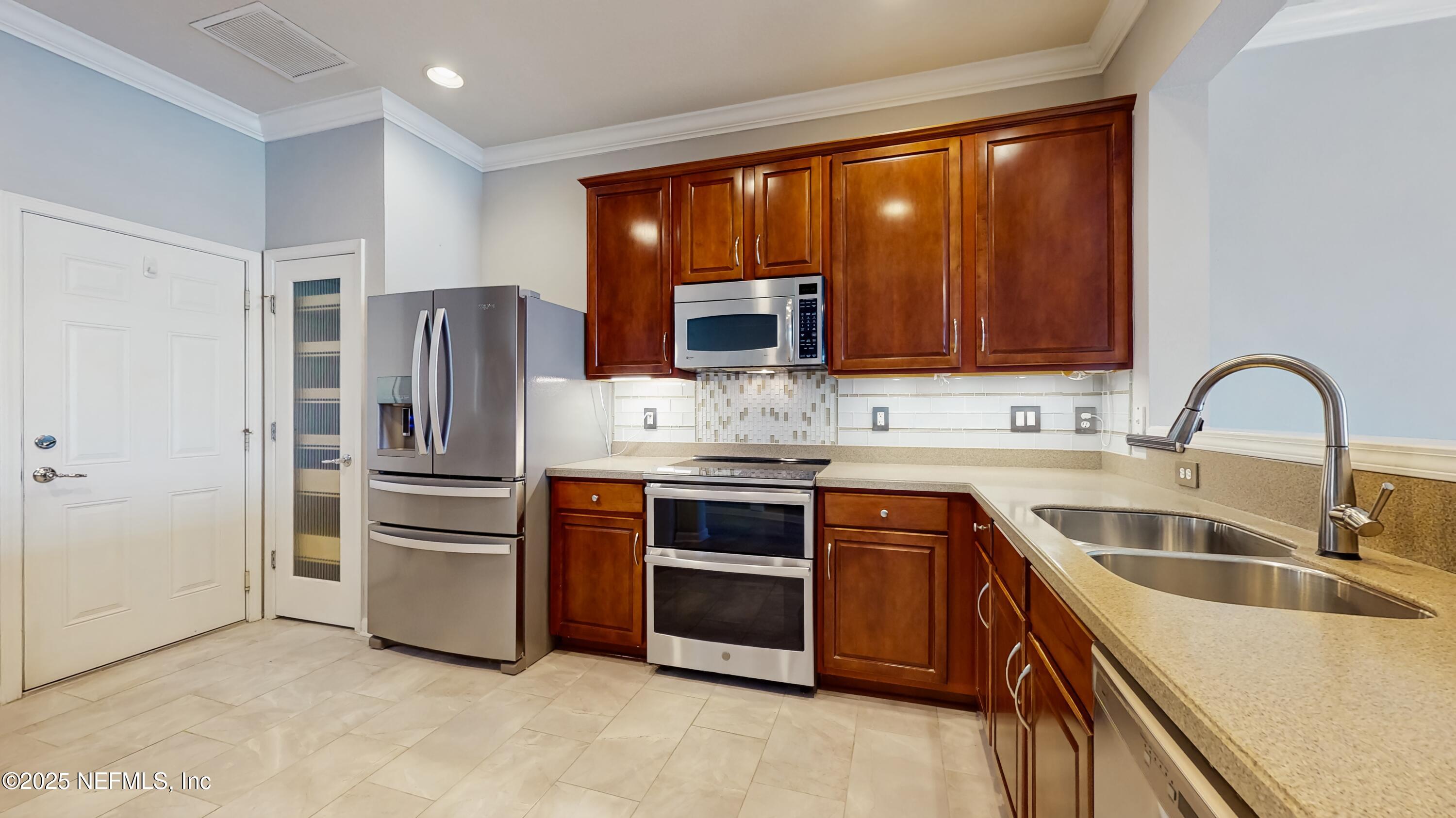 7030 Roundleaf Drive Jacksonville, FL 32258 - Photo 10 of 39 a kitchen with a sink cabinets and stainless steel appliances