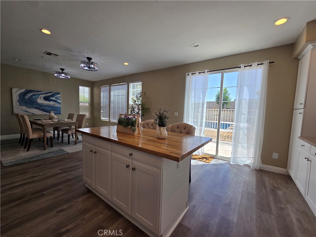 20329 Red Poppy Lane Riverside, CA 92508 - Photo 13 of 24 a dining hall with stainless steel appliances granite countertop a refrigerator a sink dishwasher a dining table and chairs with wooden floor