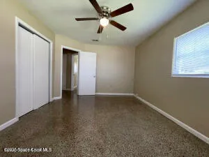 an empty room with closet and windows