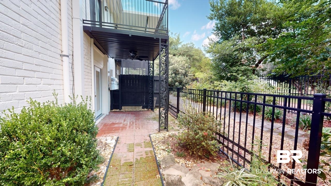 4009 Old Shell Road, Unit C13 Mobile, AL 36608 - Photo 24 of 32 Fenced backyard featuring a ceiling fan, a balcony, and a patio