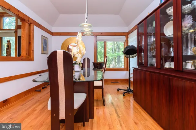a view of a dining room with furniture a chandelier and large windows