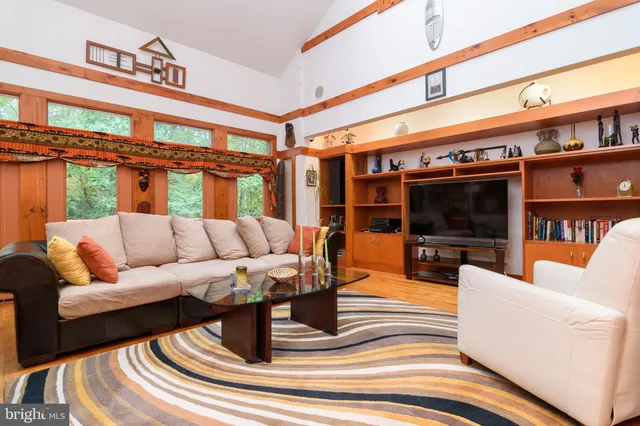a living room with furniture a flat screen tv and a floor to ceiling window
