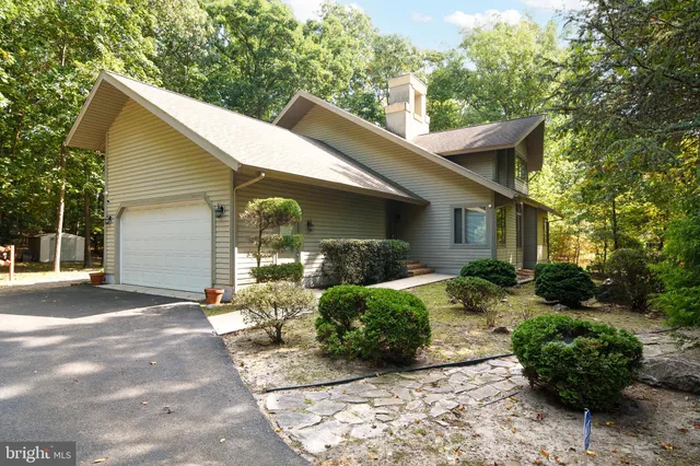 a front view of a house with a yard and potted plants