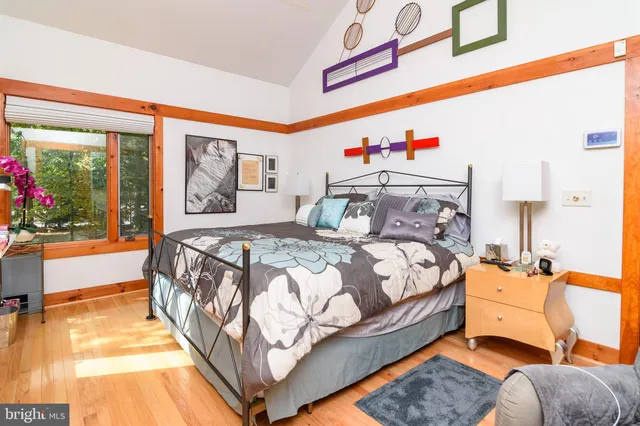 a bedroom with bed and wooden floor