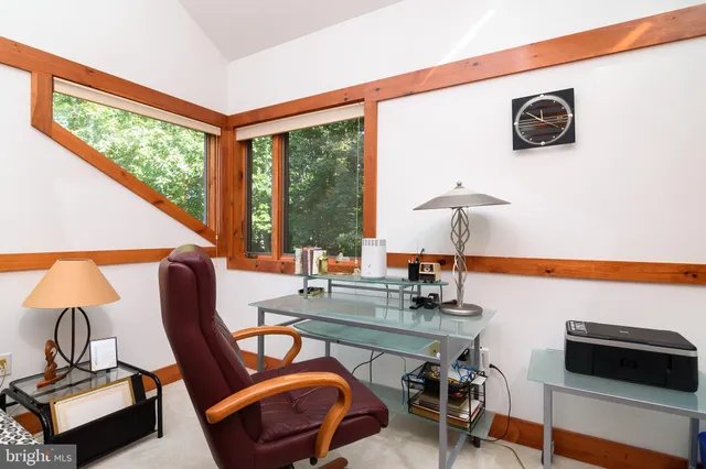 a view of a workspace with furniture and a window