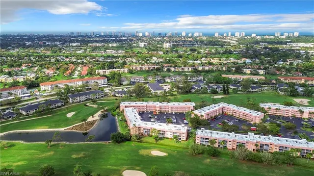 an aerial view of a city with lots of residential buildings ocean and mountain view in back