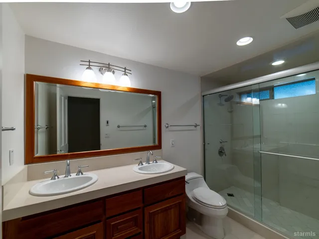 a bathroom with a double vanity sink mirror and toilet