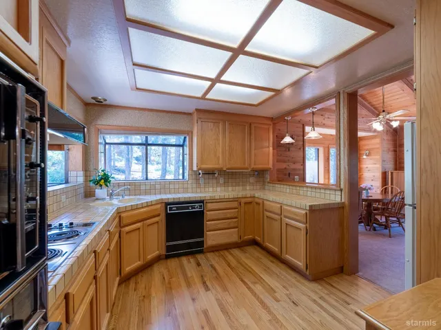 a kitchen with stainless steel appliances granite countertop wooden floors and white cabinets